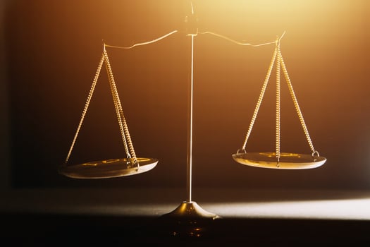 Business and lawyers discussing contract papers with brass scale on desk in office. Law, legal services, advice, justice and law concept picture with film grain effect photo