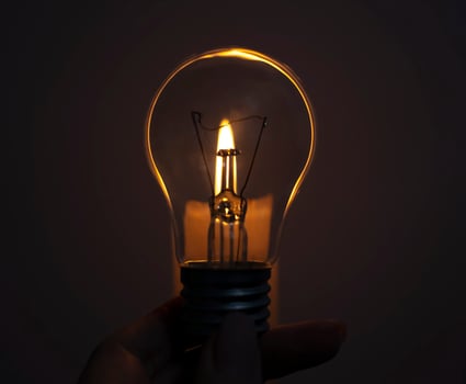 Candle on light bulb. Blackout, electricity off, energy crisis or power outage, concept image photo