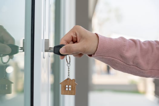 Landlord key for unlocking house is plugged into the door. Second hand house for rent and sale. Owner use hand unlock door mortgage for new home, buy, sell, renovate, investment, owner, estate photo