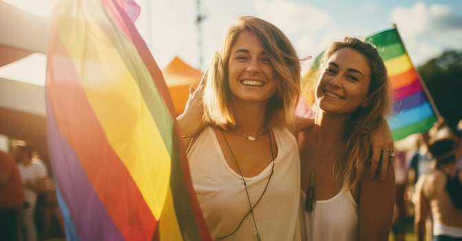Lesbian couple at pride parade, flags fluttering. photo