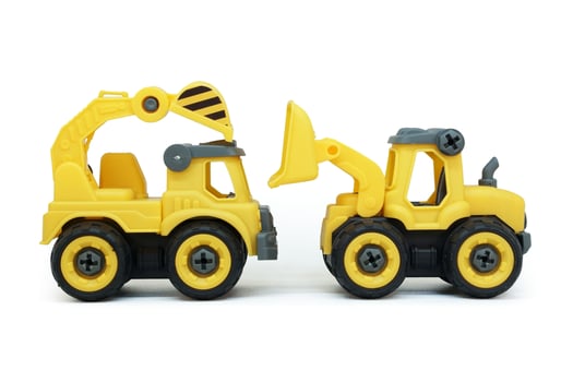 yellow plastic truck and bulldozer toy facing each other isolated on white background. heavy construction vehicle. photo