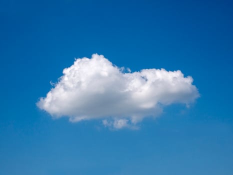 Single white cloud over blue sky background. Fluffy cloud shape photo