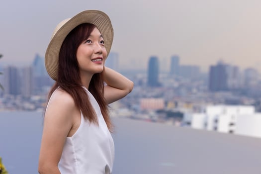 Asian woman tourist enjoying her rooftop panoramic view with cityscape background for vacation and travel photo