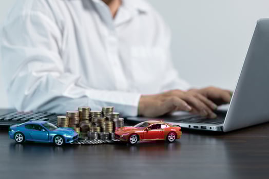 Blue and red Toy Car In Front Of Businessman Calculating Loan. Saving money for car concept, trade car for cash concept, finance concept. photo