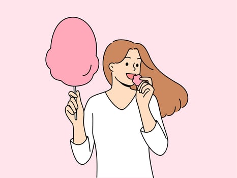 mulher come algodão doce, desfrutando arejado açúcar sobremesa enquanto caminhando dentro parque ou às justo foto