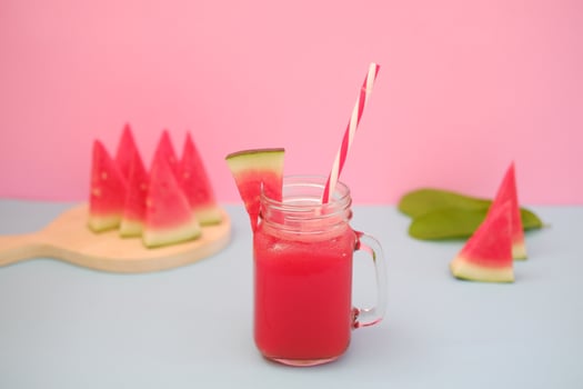 Watermelon smoothie in a glass jar with straws as a background photo