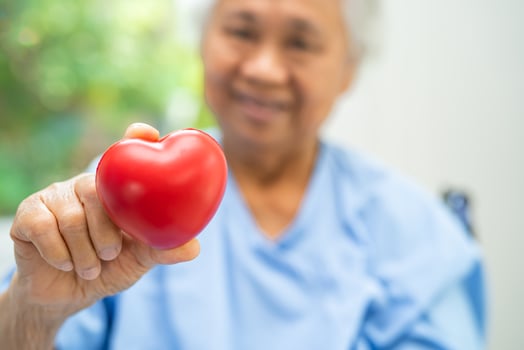 Doctor holding a red heart in hospital, healthy strong medical concept. photo