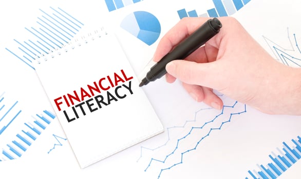 Businessman holding a black marker, notepad with text FINANCIAL LITERACY, business concept photo