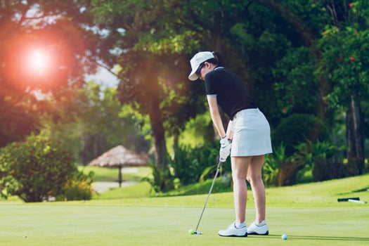 woman putting golf on green photo