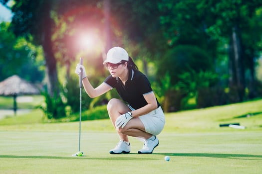 woman approach for looking golf put shot on green golf hole photo