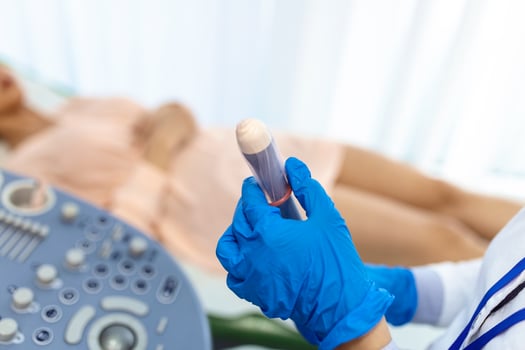 Gynecologist places ultrasound probe cover on a transvaginal ultrasound scanner for vaginal examination of a woman using an ultrasound machine. Ultrasound of the pelvic organs. Shooting close-up. photo