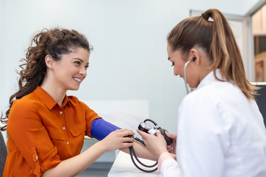 Measuring blood pressure. Young woman have a visit with female doctor in modern clinic. Measuring blood pressure. Pressure gauge. Hypertension and high heart rate photo