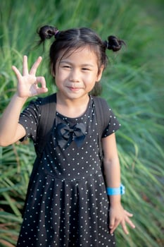 asian children with smiling face and hand sign for okay photo