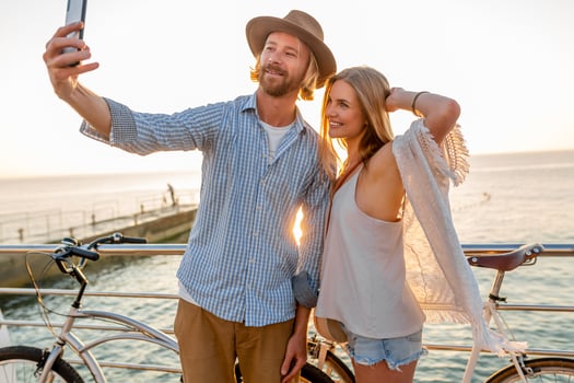 attractive happy couple traveling in summer on bicycles photo