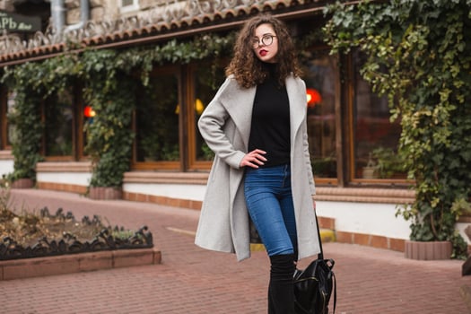 young beautiful woman walking in the city street in grey coat photo
