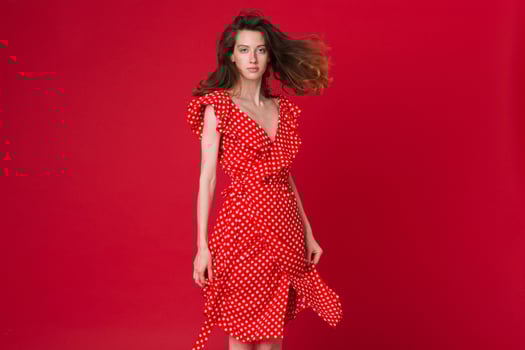 stylish woman in summer fashion trend dress on red background photo