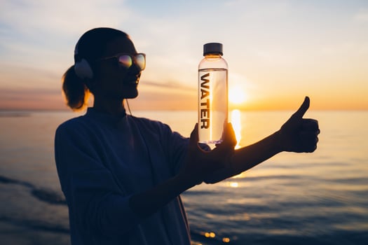 woman at sea holding bottle of water photo
