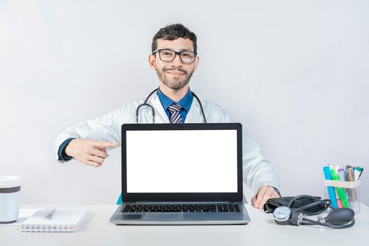 Smiling doctor pointing at an advertisement on the laptop screen. Handsome doctor pointing at an advertisement on the laptop screen photo