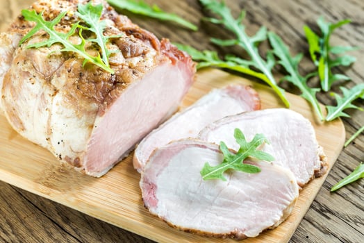 Baked meat with fresh rocket salad on the wooden board photo
