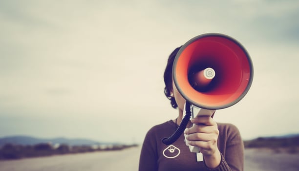 Young adult businessman shouting with megaphone outdoors, communicating message to public generated by AI photo