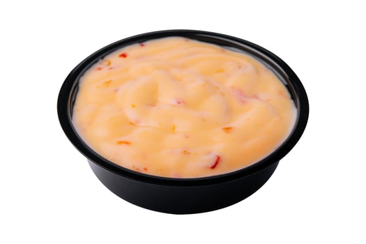 Creamy cheddar sauce isolated on white photo