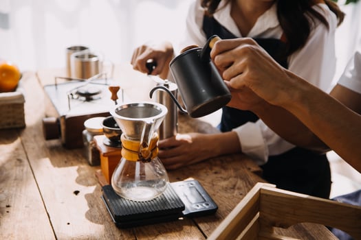 Happy young adult couple making breakfast and drinking coffee together in cozy home kitchen in morning at home. Preparing meal and smiling. Lifestyle, leisure and Love concept. photo
