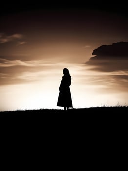 Silhouette of a lonely woman stands alone photo