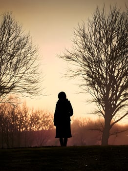 Silhouette of a lonely woman stands alone photo