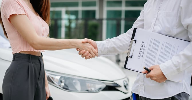 Automotive business, car sale or rental concept Customer with car dealer agent making deal and signing on agreement document contract in auto showroom or on road photo