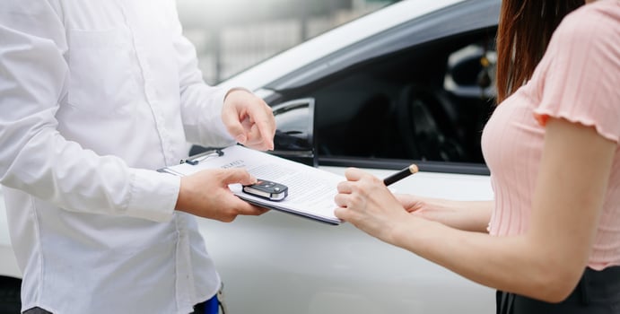 Automotive business, car sale or rental concept Customer with car dealer agent making deal and signing on agreement document contract in auto showroom or on road photo