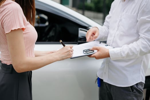 Automotive business, car sale or rental concept Customer with car dealer agent making deal and signing on agreement document contract in auto showroom or on road photo