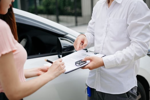 Automotive business, car sale or rental concept Customer with car dealer agent making deal and signing on agreement document contract in auto showroom or on road photo