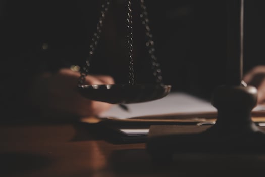 Business and lawyers discussing contract papers with brass scale on desk in office. Law, legal services, advice, justice and law concept picture with film grain effect photo