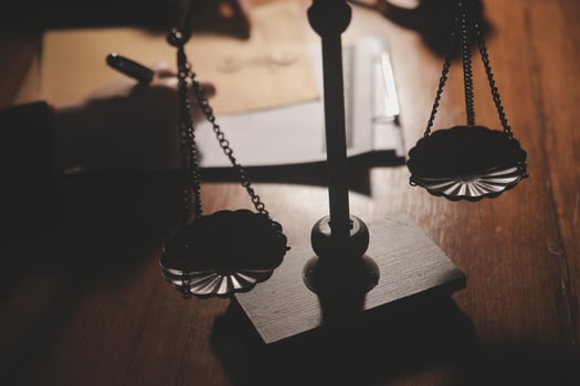 Business and lawyers discussing contract papers with brass scale on desk in office. Law, legal services, advice, justice and law concept picture with film grain effect photo