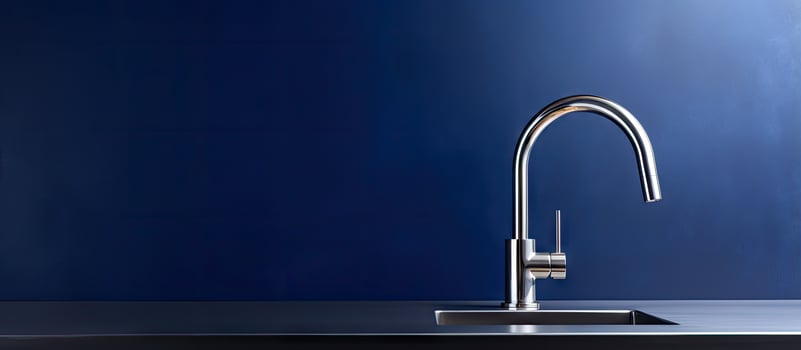 Contemporary faucet on dark blue backdrop photo