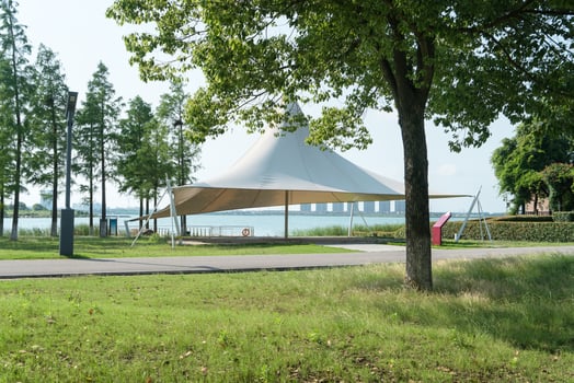 A sailboat tent by the lake, public park scenery. photo