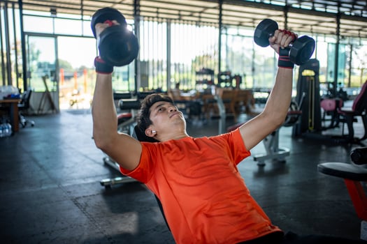young man working out with dumbbells in the gym photo