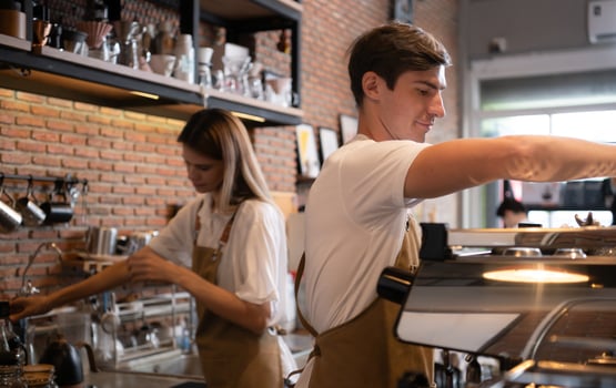 Barista working in cafe. Portrait of young male barista standing behind counter in coffee shop. photo