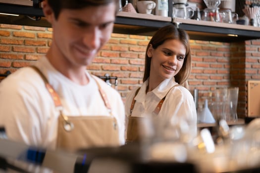 Barista working in cafe. Portrait of young male barista standing behind counter in coffee shop. photo
