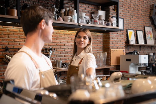 Barista working in cafe. Portrait of young male barista standing behind counter in coffee shop. photo