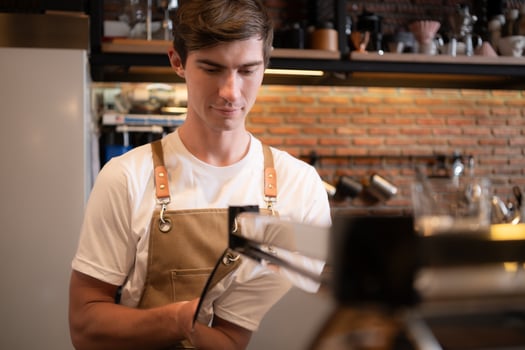 Portrait of a young male barista preparing coffee in a coffee shop photo