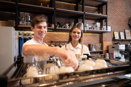Barista working in cafe. Portrait of young male barista standing behind counter in coffee shop. photo