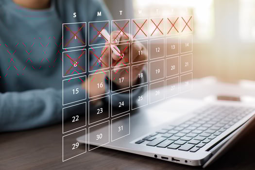 Business people use pen to write crossed-out online calendars and write a message on empty notebook paper while using a laptop to text messages, desktop view, Scheduling of meetings and appointments. photo