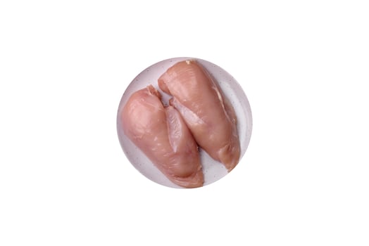 Pieces of raw chicken or turkey fillet with salt, spices and herbs photo
