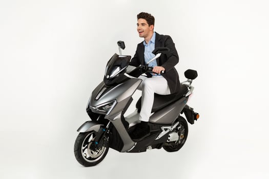 handsome man riding on electic motorbike scooter isolated on white studio background photo