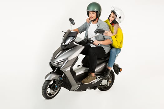 young attractive couple riding an electric motorbike scooter happy having fun together photo