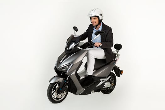 handsome man riding on electic motorbike scooter isolated on white studio background photo