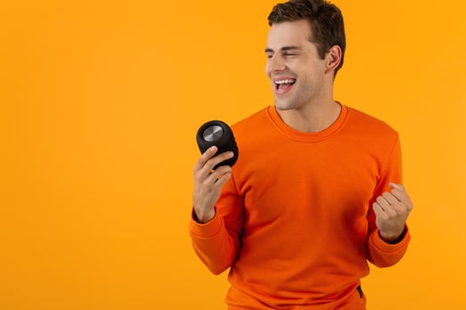 stylish young man holding wireless speaker photo