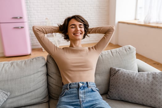 pretty young woman realxing at home sitting on sofa, smiling, happy, free time photo