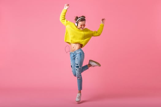 attractive woman in cheerful exited mood listening to music in headphones photo
